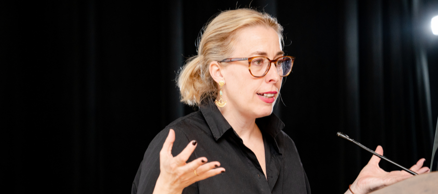 women giving a lecture with a black backdrop